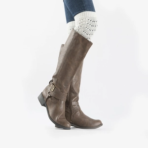 Close-up of white knitted openwork leg warmers with scalloped edges over brown boots