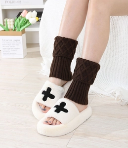 Close-up of cozy dark brown knit leg warmers paired with plush faux fur slippers