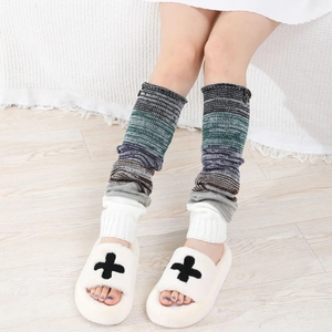 Détail de jambières en tricot rayé multicolore avec texture côtelée et boutons décoratifs