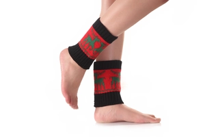 Détail de jambières de Noël tricotées avec motifs de rennes et poignets côtelés