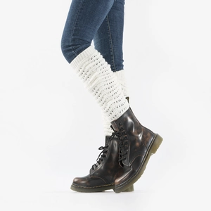 Detailed knit texture of white leg warmers with hollow wavy pattern over brown boots