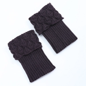 Detail of dark purple knitted leg warmers with diamond pattern and ribbed texture