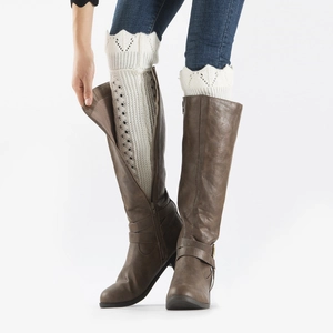 Detailed view of hollow knit leg warmers paired with brown leather boots for women