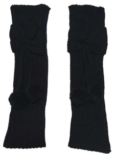 Close-up of black ribbed knit leg warmers with bow and plush pom-pom details