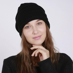 Close-up of black ribbed knit beanie showing soft texture and folded brim on a model