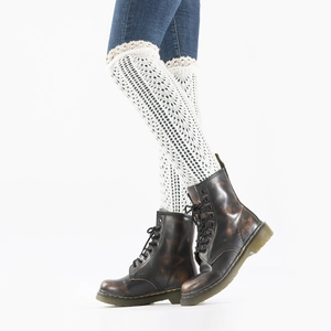 Close-up of white knitted leg warmers with lace edges and geometric hollow patterns