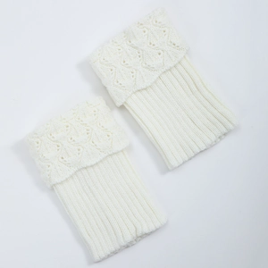 Close-up of white knitted boot cuffs with scallop hollow pattern and ribbed texture