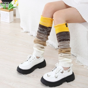 Détail de jambières en maille rayée avec boutons et chaussures blanches à nœud papillon