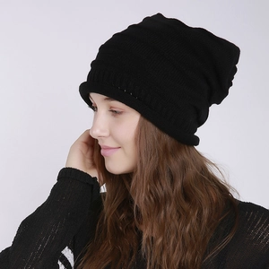 Detail of black knitted beanie showing horizontal ribbed texture and elastic slouchy fabric