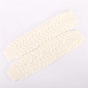 Detail of cream white cable knit leg warmers with wavy cutout patterns and ribbed cuffs