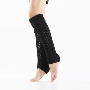 Detail of black open-knit leg warmers showing hollow diamond pattern and stirrup cuff