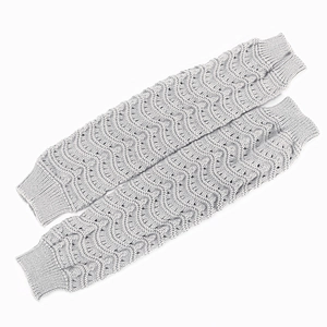 Close-up of light gray knitted leg warmers with wave patterns and ribbed cuffs