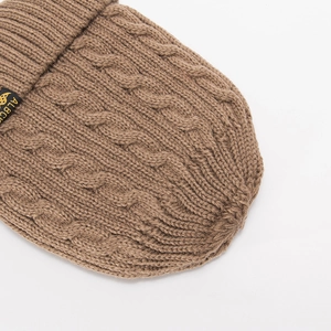 Close-up of brown cable knit beanie showing warm woolen texture and side woven label