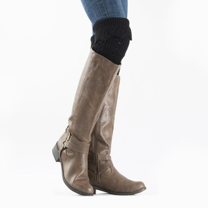 Detail of black openwork lace knitted leg warmers with brown buckled leather boots
