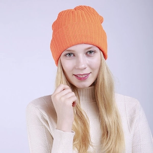 Close-up of bright orange ribbed knit beanie showing soft wool texture and warm double layers