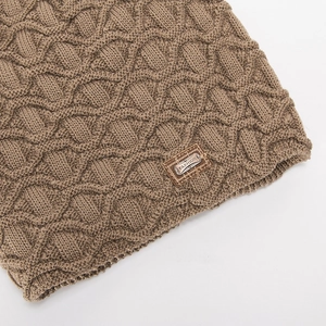 Detail der khakifarbenen Zopfstrickstruktur mit modischem Leder-Metall-Patch auf Wintermütze