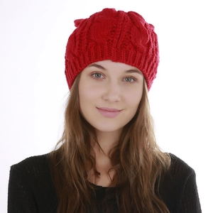 Close-up detail of red cable knit winter beanie showing soft texture and pattern