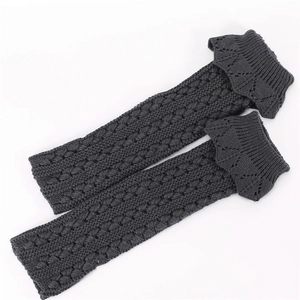 Detailed knit texture of dark grey leg warmers with scalloped ruffle edge trim