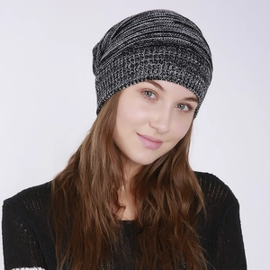 Close-up of a slouchy knitted beanie showing black and white mixed texture and soft fabric