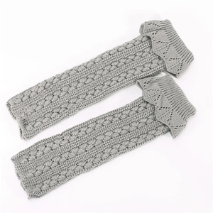 Detail of light grey knit leg warmer showing hollow pattern and ruffled edge texture