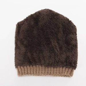 Close-up of winter knit beanie showing the thick brown fleece lining and camel cable texture