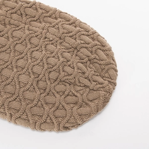 Makroaufnahme einer dunkelbraunen Wintermütze mit dickem Zopfmuster und Rautenstrickdetails