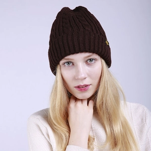 Close-up of deep brown cable-knit beanie featuring thick textured wool blend fabric
