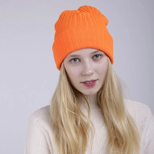 Detailed texture of orange ribbed knit beanie with folded cuff and thick winter fabric