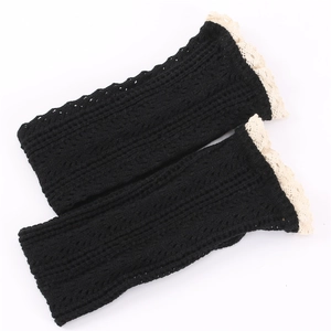 Detail of black knit leg warmers featuring intricate crochet mesh and white lace trim