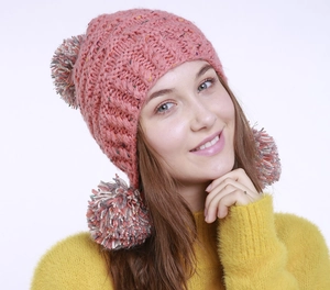 Detail der rosa Strickmütze mit drei bunten Pompons aus gemischtem Garn für Damen