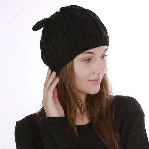 Detail of black cable knit beanie featuring cute cat ear design and thick texture