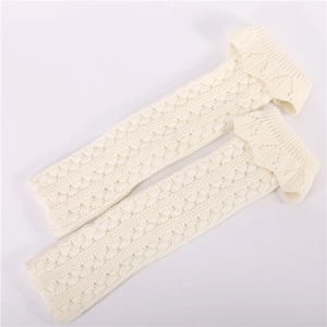 Detailed knit texture of cream leg warmers featuring hollow patterns and scalloped edges