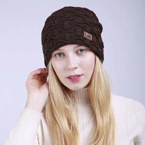Detail der Strickstruktur und Lederpatch an einer dunkelbraunen Winter-Strickmütze