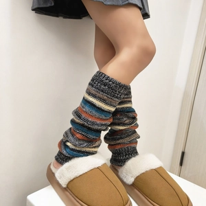 Λεπτομέρεια από πλεκτές γκέτες με ρίγες boho και μπεζ λούτρινα παντοφλάκια για το χειμώνα