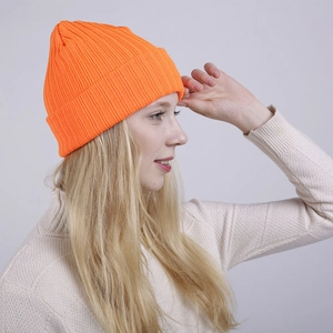 Close-up of bright orange ribbed knit beanie showing double-layer texture and folded cuff