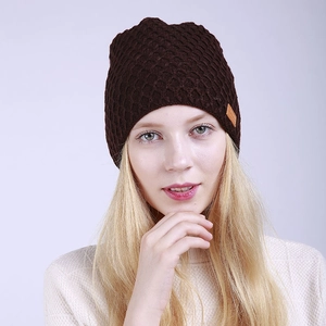 Detalle del tejido de punto y la etiqueta de cuero de un gorro de invierno marrón