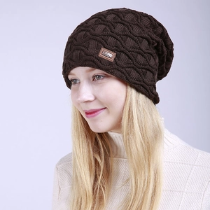 Detail einer dunkelbraunen Strickmütze mit 3D-Rautenmuster und Leder-Mode-Etikett