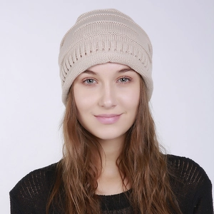 Close-up of light beige knit beanie with horizontal stripe texture and hollow patterns