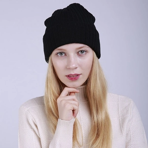 Detail of a black ribbed knit beanie on a woman for winter warmth and comfort