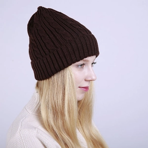 Detailed close-up of dark brown chunky cable knit beanie with thick fold-over cuff