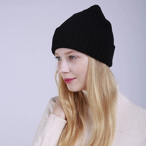 Detail view of the ribbed knit texture and soft fabric on a black winter beanie hat