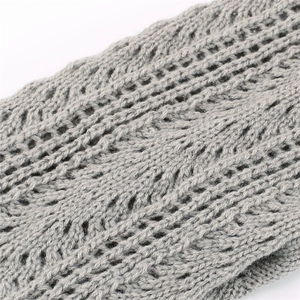 Gray knitted leg warmers featuring openwork mesh patterns and wavy lace textures