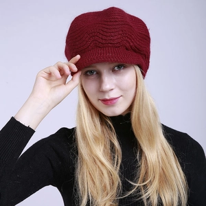 Close-up of wine red knitted beanie with peak and wave pattern texture for winter