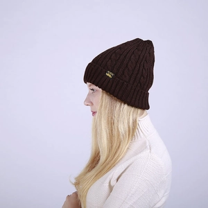 Detailed close-up of dark brown cable knit beanie showing thick texture and ALBCK label