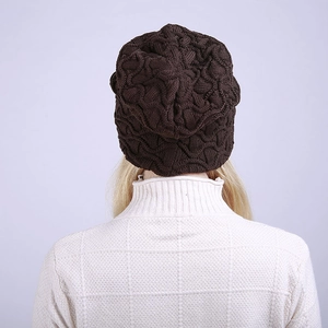 Detailaufnahme einer dunkelbraunen Strickmütze mit dickem Zopfmuster und Beanie-Schnitt