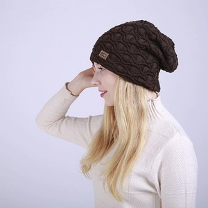 Nahaufnahme einer braunen grob gestrickten Beanie mit Lederpatch an einem Model