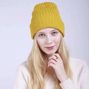 Macro detail of mustard yellow ribbed knit beanie showing thick texture and folded cuff