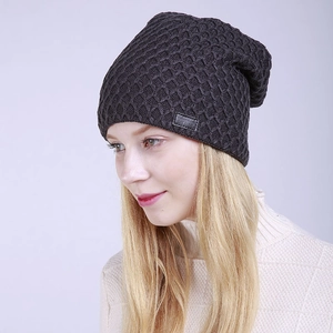 Detalle de gorro de punto gris oscuro con textura de panal y etiqueta de cuero