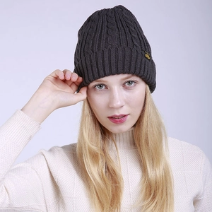 Dark grey cable knit beanie for winter featuring a cuffed design and brand label