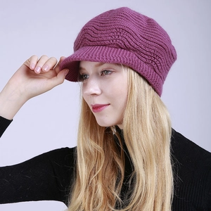 Detail of purple knitted newsboy hat showing warm wavy texture and short brim design